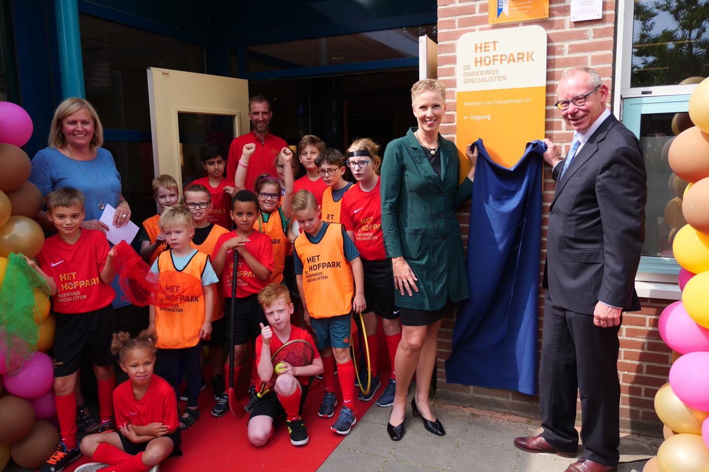 Astrid Berendsen (College van Bestuur De Onderwijsspecialisten) en wethouder Detlev Cziesso (gemeente Apeldoorn) onthullen de nieuwe naam